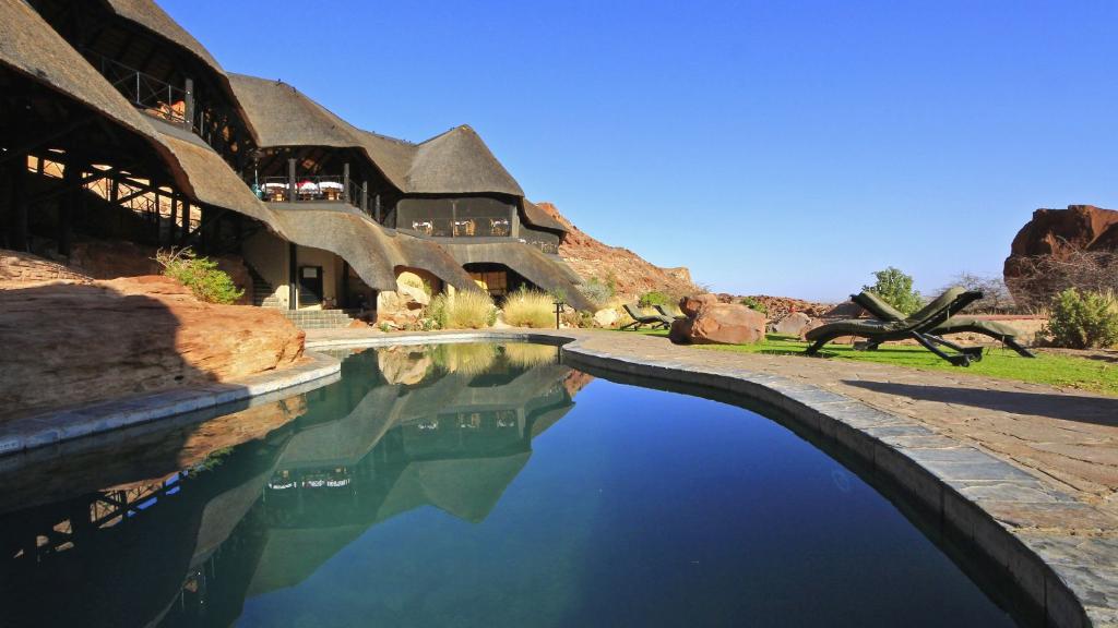 Pool und Haupthaus der Twyfelfontein Country Lodge in Namibia | Abendsonne Afrika
